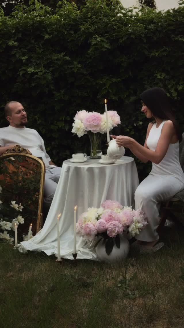 Couple at a garden tea table with peonies and candles